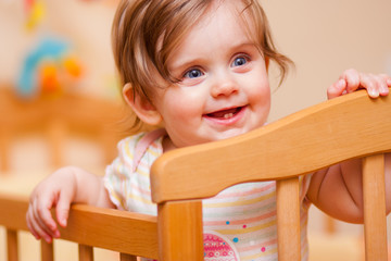 little girl standing in the crib