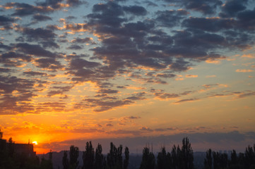 Landscape with dramatic light - beautiful golden sunset with saturated sky and clouds.