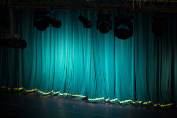 Theater stage with a curtain and spotlights in front of the performance.