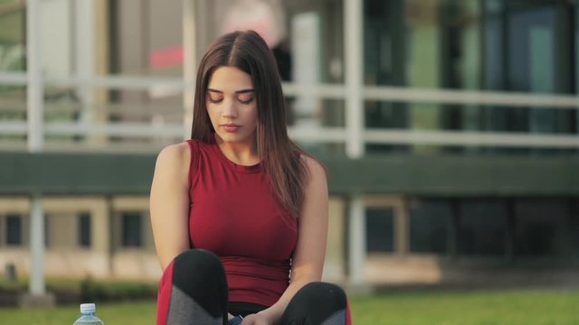 Woman making pause in the park after jogging / exercise,