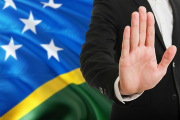 Solomon Islands rejection concept. Elegant businessman is showing stop sign with hand on national...