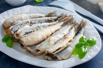 Fried smelt on a white dish, selective focus