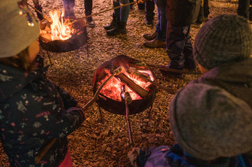 Kinder am Lagerfeuer mit Holzspieße im Feuer