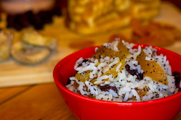 handmade preparation of treats for traditional Orthodox Christmas - rice pudding with fruits, cranberries, honey, nuts, Church candles