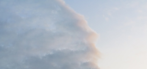 Beautiful puffy clouds at sunset isolated against pastel blue and pink skies