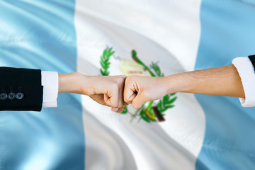 Guatemala agreement concept. Man and woman fist bumping on national flag to show cooperation. Peace and teamwork theme.