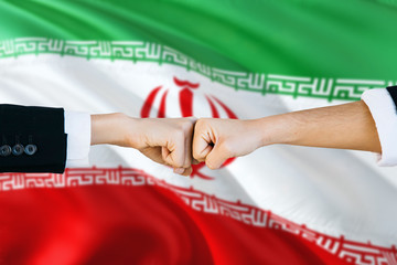 Iran agreement concept. Man and woman fist bumping on national flag to show cooperation. Peace and teamwork theme.