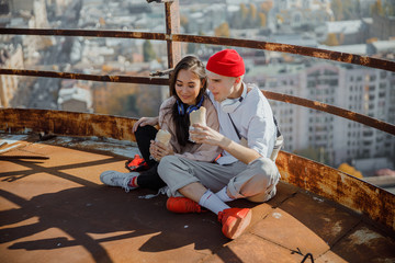 Young guy is hugging his girlfriend on roof