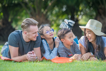 Happy family day vacation spend time together, lying on green grass in the park.