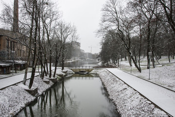 snowy park and narrow river