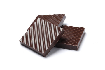 Black chocolate pieces isolated on a white background.