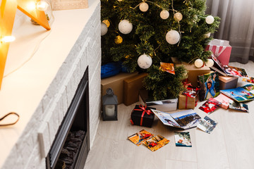 book together near Christmas tree in front of fireplace