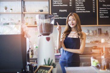 Portrait young Asian woman barista feeling happy smiling at urban cafe. Small business owner Korean girl in apron relax toothy smile