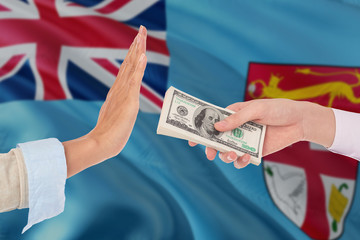 Fiji bribery refusing. Closeup of female hands extending a pile of dollar bills to the male hands gesturing as if rejecting the money.