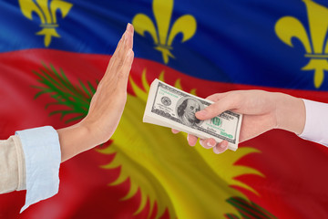 Guadeloupe bribery refusing. Closeup of female hands extending a pile of dollar bills to the male...