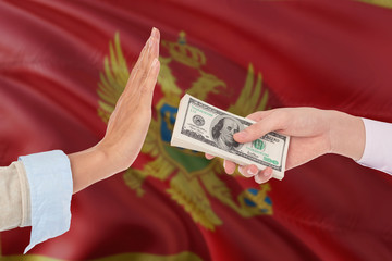 Montenegro bribery refusing. Closeup of female hands extending a pile of dollar bills to the male...