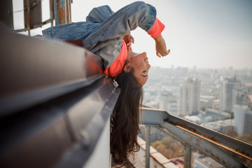 Smiling pretty Asian girl holding hands up on the roof