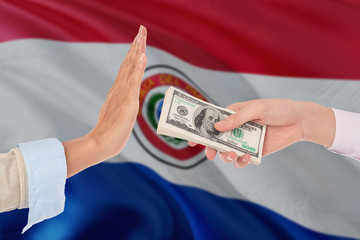 Paraguay bribery refusing. Closeup of female hands extending a pile of dollar bills to the male hands gesturing as if rejecting the money.