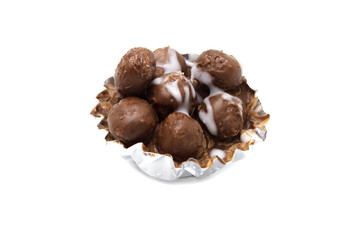 Chocolate mini balls inside of the cup on white background.