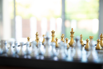 Gold chess game face with the another silver team background .Concept strategy