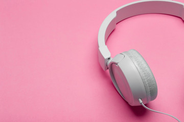 Musical headphones on a colored pink background. Aesthetics retro 80s and minimal concept