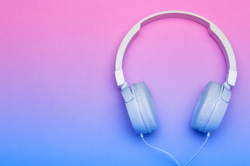 Musical headphones on a colored blue and pink background. Aesthetics retro 80s and minimal concept
