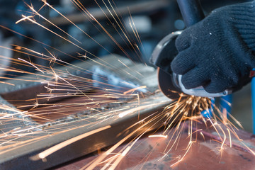 Cut metal with a Angular grinding machine. Sparks are flying. Construction tool grinder. A man is...