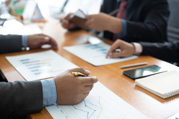 Closeup hand team business analysts make decisions about the US economy that affect future operations of the company.concept