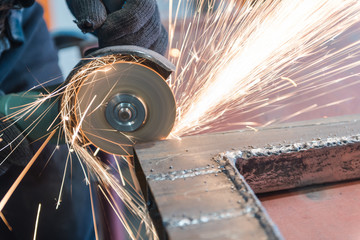 Cut metal with a Angular grinding machine. Sparks are flying. Construction tool grinder. A man is cutting metal. Wear gloves for safety.