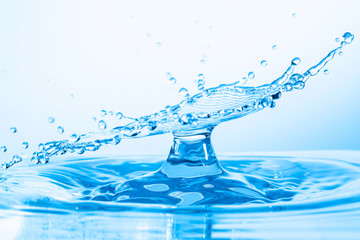 Close up macro of splash of falling drops of water and impact to a other drop of water and form...