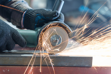 Cut metal with a Angular grinding machine. Sparks are flying. Construction tool grinder. A man is...