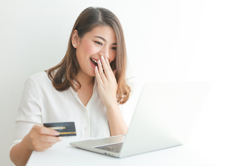 Asian woman using credit card shopping online with laptop computer on white background