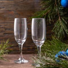 Glasses for champagne and a bottle on the background of New Year's decor. Copy space. Close-up.