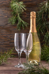Glasses for champagne and a bottle on the background of New Year's decor. Copy space. Close-up.