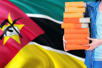 Mozambique national education concept. Close up of female student holding colorful books with...