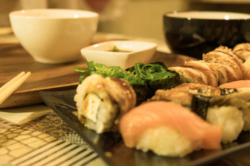 Many different sushi rolls on a plate close up. Serving on the table in the restaurant