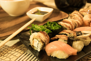 Many different sushi rolls on a plate close up. Serving on the table in the restaurant