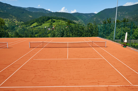 Empty outdoor tennis court in a picturesque landscape on a sunny day