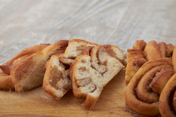 Twisted traditional Swedish cinnamon rolls at a café. The sweet buns are on a wooden chopping board.