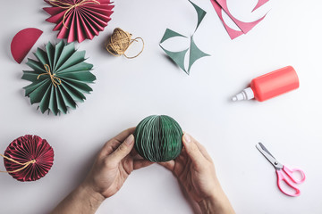 Christmas handmade background. Female hands making paper decoration balls. Step by step. DIY...