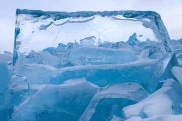 Beautiful view on field of  turquoise blue broken ice through the transparent geometry ice block, scenic winter lanscape