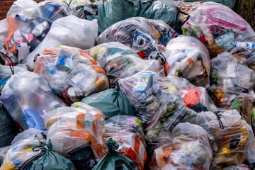 Close-up of a big pile of trash bags filled with domestic waste in a city street 