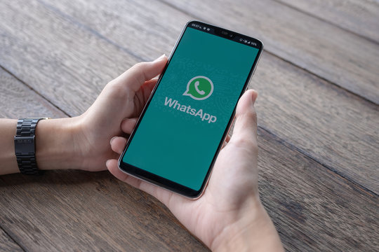 CHIANG MAI, THAILAND - May 11 2019 : Man holding a Oneplus 6 and open appstore searching social Internet service WhatsApp on the screen.