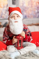 a little boy dressed as a Christmas gnome with a beard holding a red lantern