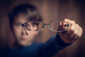 Kind hällt Brille vors Gesicht