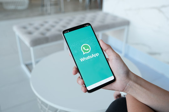 CHIANG MAI, THAILAND - Dec 1, 2019 : Woman holding a Oneplus 6 and open appstore searching social Internet service WhatsApp on the screen.