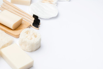 Zero waste with natural biodegradable self care products on blue. Bamboo toothbrushes, handmade soap shampoo bars, cotton buds pads, hygiene products luffa on white, selective focus