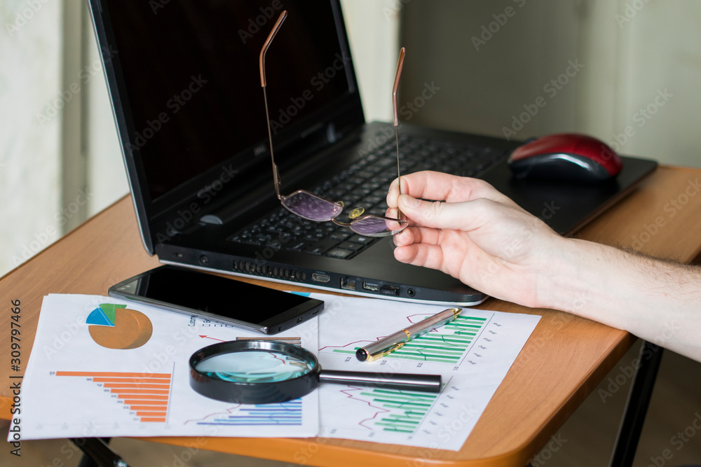 Poster analysis and research of financial mobile data on business chart in office.