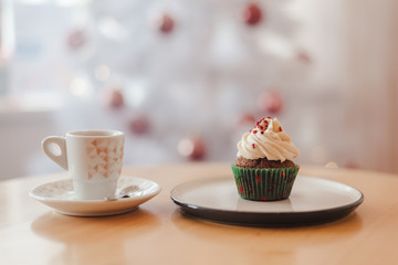 coffee Cup and cake on the table near the Christmas tree