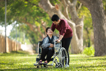 Asian senior woman on wheelchair with son